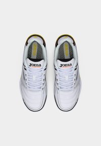 Λευκά αθλητικά παπούτσια με υφή στην επάνω επιφάνεια, μαύρες λεπτομέρειες και κίτρινες διακοσμήσεις. Διαθέτουν λογότυπο στη γλώσσα και σύστημα κορδονιών για ασφαλή εφαρμογή.