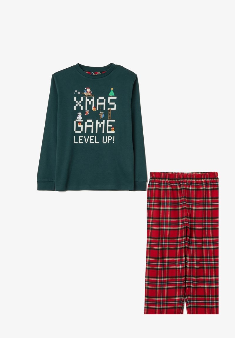 Sudadera verde oscuro con arte pixelado navideño y texto "¡XMAS GAME LEVEL UP!", combinada con pantalones de pijama de cuadros rojos y negros.