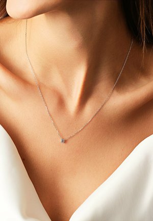 Sølv kæd necklace med en rund, klar sten vedhæng. Enkel design, der har en delikat tekstur og minimalistisch stil.