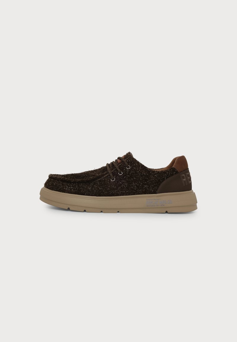 Chaussure basse marron foncé texturée à lacets, semelle beige et patch en cuir au talon, vue de côté sur fond clair uni.