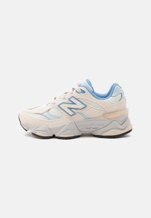 Baskets blanches et bleu clair avec panneaux en mesh et suède, semelle matelassée et logo "N" sur le côté.