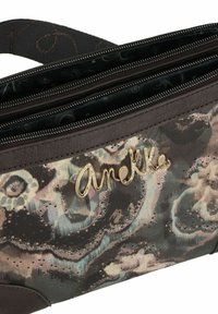 Borsa multi-scomparto in tessuto scuro con motivi floreali, dettagli metallici e logo dorato "Anelka". Caratterizzata da chiusure con zip e dettagli testurizzati.