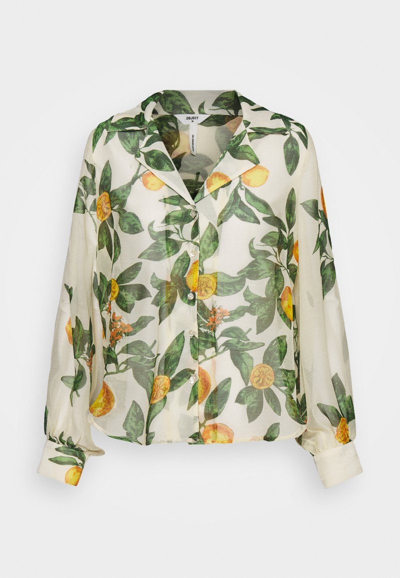 Blouse blanche transparente à manches longues avec imprimé de feuilles vertes et de fruits orange, boutonnage devant et col décontracté.