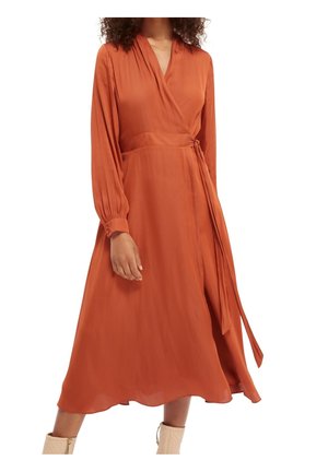 Robe portefeuille orange brûlé à manches longues, en tissu doux, avec une ceinture à nouer. La jupe tombe jusqu'au milieu du mollet, présentant un design léger et des accents minimalistes.