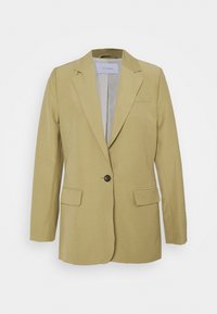 Blazer vert olive avec un seul bouton foncé, des revers à crans, deux poches avant et une texture de tissu léger. Doublure lisse visible à l'intérieur.