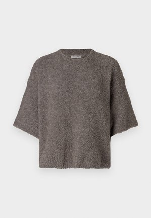 Pruun, tekstuuriga, ülisuur kudum, millel on lühikesed varrukad ja ümmargune kaelus. Pehme, udune materjal, millel on lahtine lõige ja minimaalsed disainidetailid.