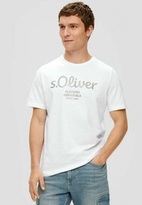 White short-sleeve t-shirt featuring a light gray graphic text "s.Oliver" and "Elevated Essentials" on the front, made of soft cotton blend.