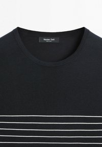 Sort crewneck-shirt med vandrette hvide striber på den nederste del af brystet, mærket Massimo Dutti, lavet i Kina.