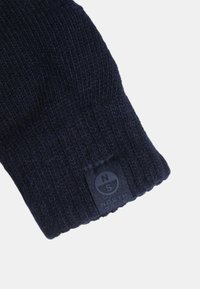 Cappello in maglia invernale di colore blu navy scuro con un'etichetta del logo North Sails cucita vicino al bordo su uno sfondo bianco.