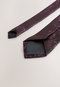 Dunkellila Krawatte mit floralem Muster in Burgunder-Tönen. Satinmaterial mit glatter Textur. Verjüngte Enden und einfarbig schwarze Fütterung.