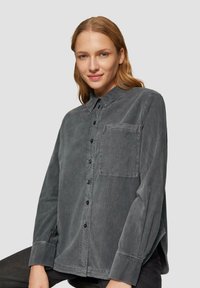 Grijze button-up overhemd van gestructureerde stof, met een borstzak, lange mouwen en zwarte knopen.