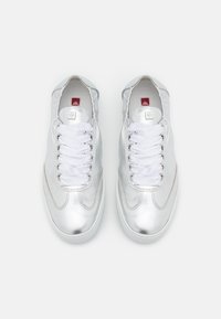 Söljmetallic sneakers med vita snörningar, rund tå och tvåfärgad sula. Har ett slätt övre material och enkla designaccent.