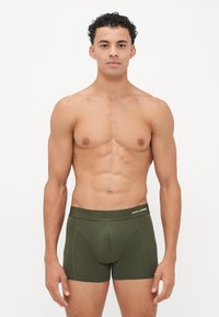 Herren Boxershorts in olivgrün mit einem weichen Bund, der eine dezente Textur und kontrastierende Nähte aufweist. Das Markenlogo ist am Bund angebracht.