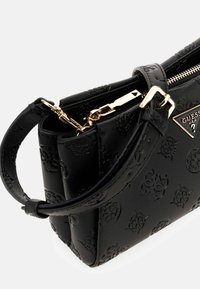 Borsa nera in rilievo con forma strutturata, dotata di una cerniera dorata, placca con logo e una maniglia corta per un facile trasporto.