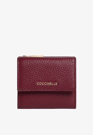 Portafoglio in pelle testurizzata color borgogna con zip dorata e nome del marchio "Coccinelle" in lettere dorate sulla patta anteriore.