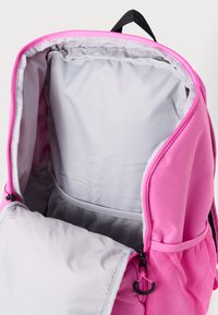 Mochila rosa con exterior suave, compartimentos con cremallera y forro interior gris. Incluye un bolsillo de malla para una mejor organización.