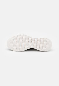 Black sneaker sole with a textured white rubber design, featuring raised horizontal and vertical lines for grip and flexibility.