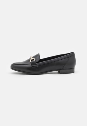 Mocassin en cuir noir avec un détail en métal doré, petit talon empilé et bout carré arrondi sur fond blanc.