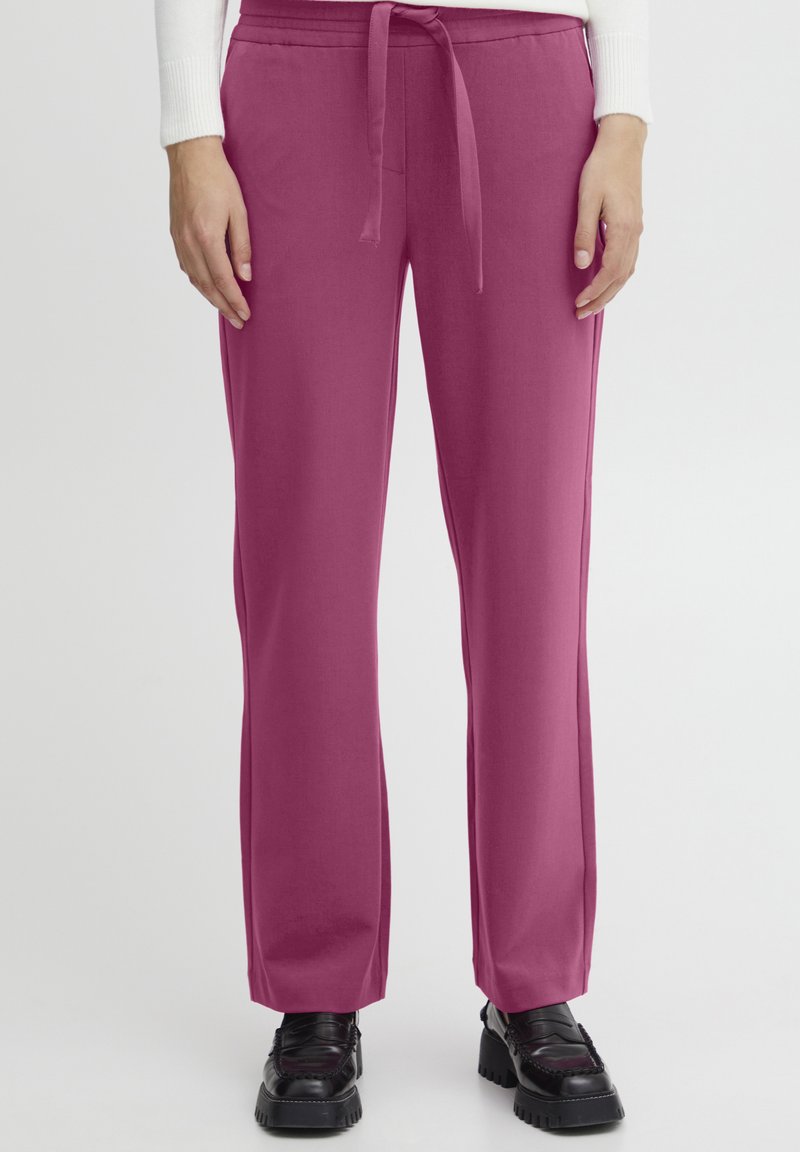Fuchsia wide-leg trousers with a drawstring waist and smooth texture, paired with black platform shoes.