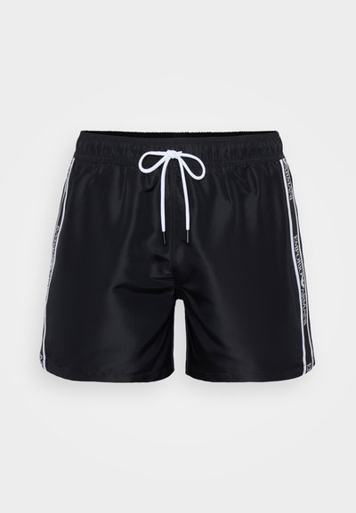 Čierne plavky z hladkej tkaniny, s elastickým pásom na šnurovanie a bielymi bočnými pruhmi s logom.
