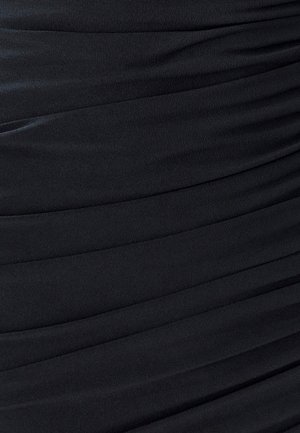 Tela de vestido negro con un diseño texturizado y acanalado. El material parece suave, fluido y ligeramente elástico, con pliegues paralelos por toda su superficie.