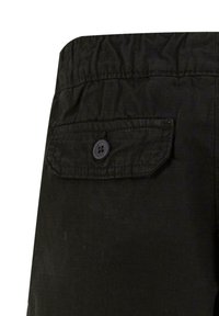 Svarte bukser med elastisk midje, med teksturert stoff, en baklomme med klaff, og to-knappslukking.