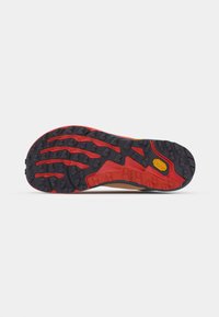 Semelle de chaussure de trail avec un design en caoutchouc noir et rouge robuste, dotée de crampons prononcés pour une meilleure traction ; une semelle intermédiaire marron et orange ajoute de la durabilité.
