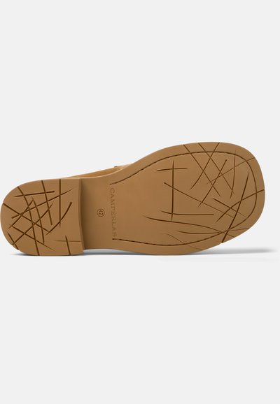 Sål af lysebrun sko med krydsede slidmønstre, størrelse 42-mærkning og "CAMPERLAB" præget nær bueområdet.