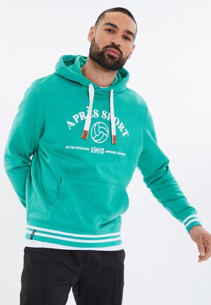 Teal hoodie med hvid retro sportsgrafik, frontlomme med kangaroo stil og stribede ribkanter og manchetter. Brune detaljer på snørebåndene.