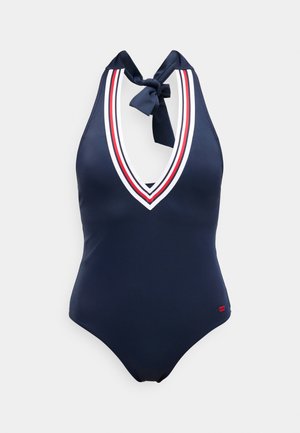 Μαγιό ολόσωμο σε ναυτικό μπλε με λαιμόκοψη halter, βαθύ V στο ντεκολτέ, λευκή και κόκκινη επένδυση και δεμένη κορδέλα στο λαιμό.