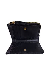 Portafoglio in pelle nera con chiusura a zip e hardware dorato. Presenta più scomparti per carte e una chiusura a pulsante. Texture liscia.