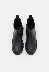 Mustat nahka ankle-bootsit, joissa on sileä pinta, rakennepohja, sivuvetoketju ja vetonauha, jotka helpottavat pukemista.