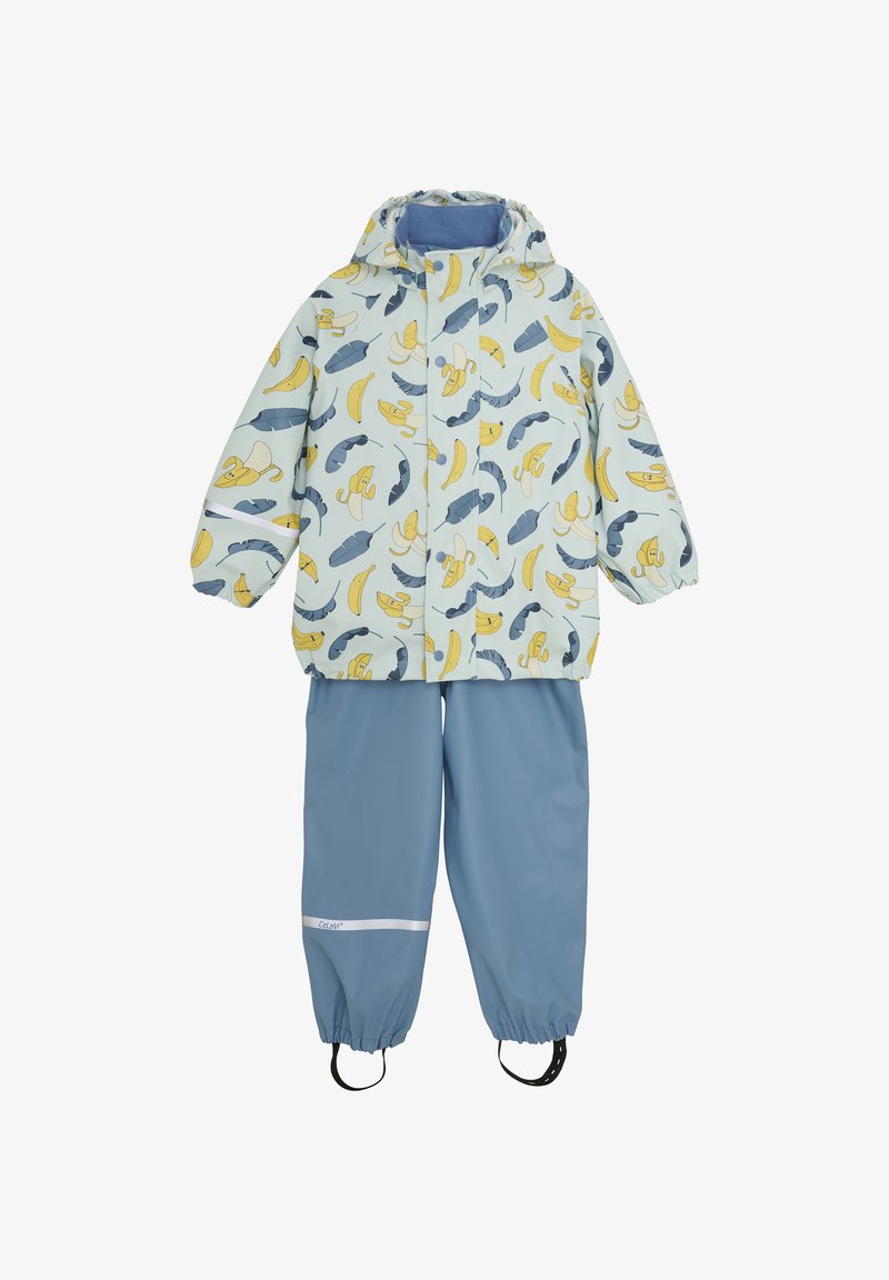 Ljusblå regnjacka och byxset, med ett mönster av bananer och fjädrar, elastiska ärmslut och reflexdetaljer på byxorna.