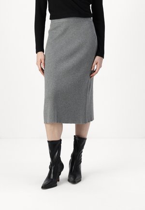 Grauer gerippter Midi-Rock mit einer taillierten Form. Kombiniert mit schwarzen High-Heel-Stiefeln, die ein elegantes Design und eine spitze Zehenpartie aufweisen.