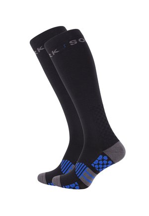 Chaussettes noires montantes en tissu extensible, avec un design texturé, des accents gris et un motif à pois bleus sur les semelles.