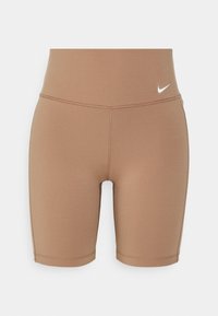 Short de sport moulant marron clair avec taille haute et petit logo blanc Nike sur la hanche droite sur fond uni.