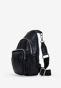 Bolso de cuero negro tipo bandolera con un acabado texturizado, que cuenta con dos compartimentos con cremallera y una correa tejida ajustable, con detalles en metal plateado.
