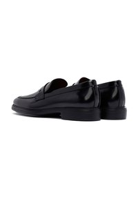 Schwarze Lederloafers verfügen über ein glattes, poliertes Finish mit einer abgerundeten Spitze und einem niedrigen Absatz. Das Design umfasst einen dekorativen Riemen an der Vorderseite.