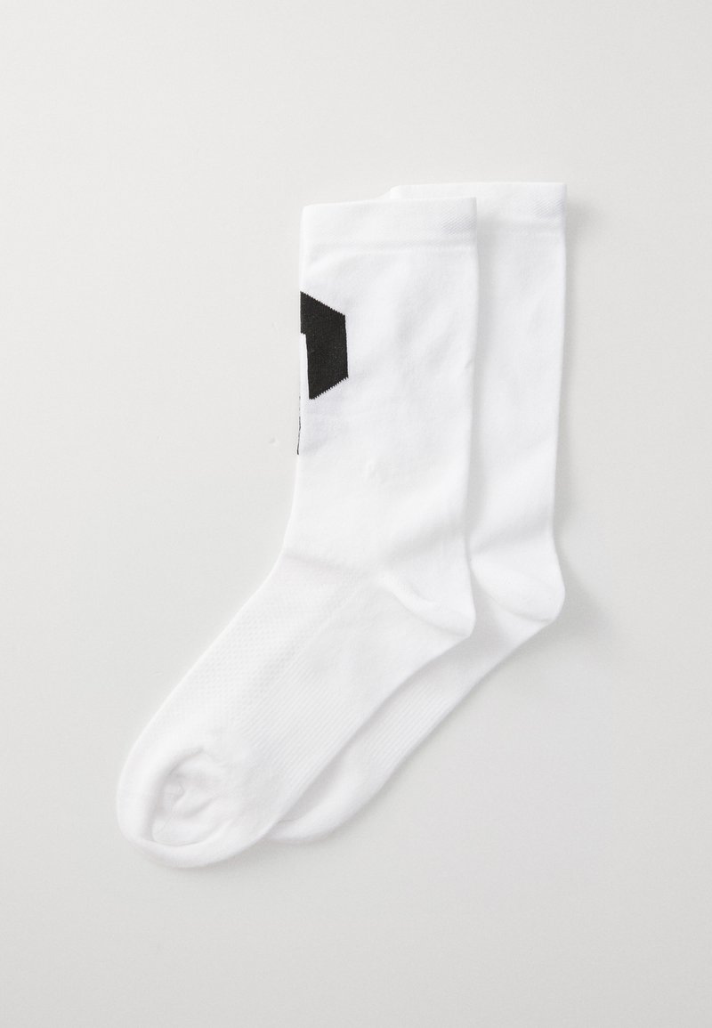 Witte katoenen sokken met een gladde textuur en een zwart geometrisch ontwerp als accent. Heeft een standaard enkel lengte en ribbel manchet.