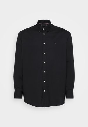 Must musta varrukat, nööpidega ja klassikalise kraega must särk, millel on valged nööbid ja väike logo rinnal. Valmistatud struktureeritud puuvillakangast.