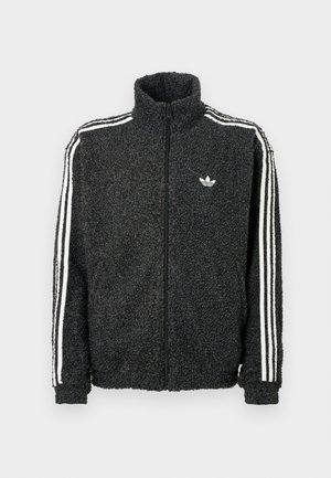 Čierna fleecová bunda so zipsom vpredu, vysokým golierom a bielymi trojprúžkovými akcentmi na rukávoch. Obsahuje malé logo na hrudi.