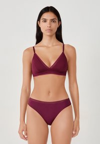 Bralette bordeaux avec bretelles ajustables et dentelle, associé à des culottes hipster assorties. Tissu lisse, design minimal, sans embellissements.