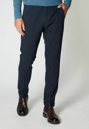 Pantaloni blu navy in cotone con taglio dritto. Presenta tasche anteriori e orli rifiniti. Abbinati a scarpe in pelle marrone.