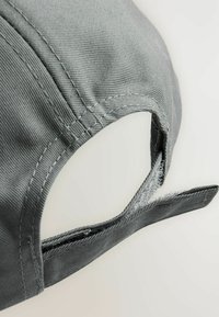 Graue Baseballkappe aus strukturiertem Stoff. Verfügt über einen verstellbaren Riemen aus einem ähnlichen Material mit sichtbaren Nahtdetails.
