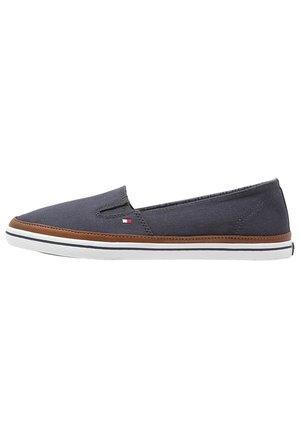 Herres slip-on sejlersko i kanvas i navy med brun kant, lille flaglogo og hvid gummisål med sort stribe.