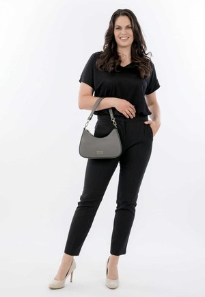 Blusa nera a maniche corte, pantaloni neri, tacchi alti beige e una borsa grigia dalla forma curvata con accenti dorati.
