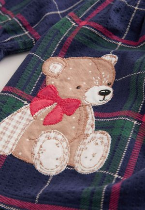 Navy fabric with a plaid pattern in green and red, featuring an embroidered brown bear with a red bow and detailed paws.