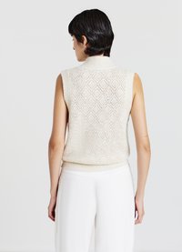 Top senza maniche in crema a maglia con motivo a diamante, caratterizzato da un collo alto e un bordo a coste. Texture morbida, progettato per una silhouette attillata.