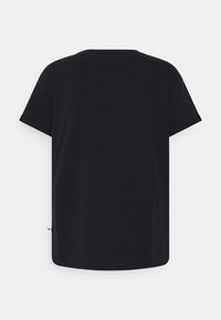 Camiseta negra de manga corta y cuello redondo vista desde atrás con una pequeña etiqueta en la costura lateral izquierda.