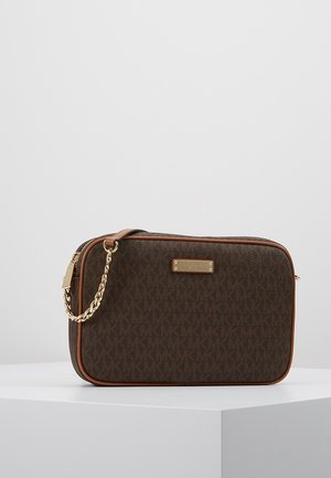 Prostokątna brązowa designerska torba na ramię z złotym łańcuszkowym paskiem, wzorem monogramu MK oraz złotą tabliczką z nazwą marki na jednolitym jasnym tle.